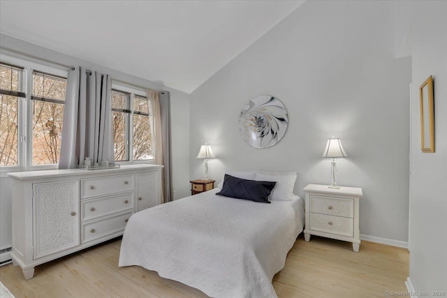 bedroom with lofted ceiling and light wood-type flooring