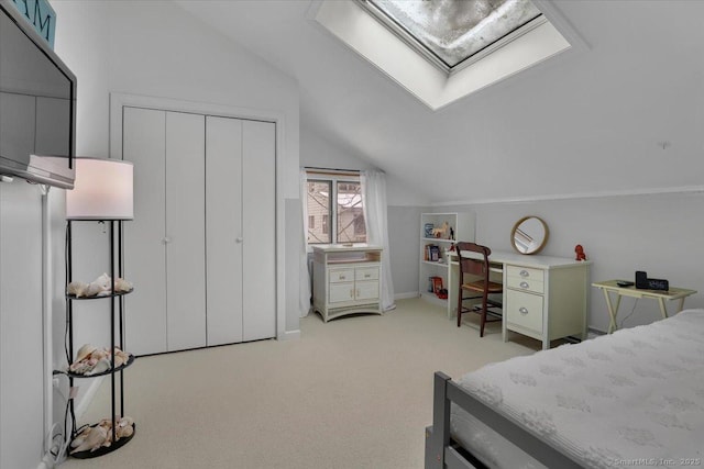 carpeted bedroom featuring a closet and vaulted ceiling with skylight