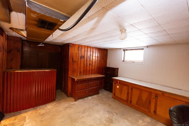 basement featuring wooden walls