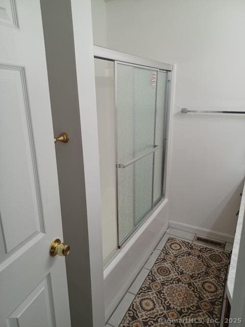 bathroom with tile patterned floors and enclosed tub / shower combo