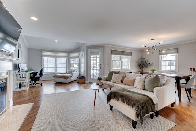 living room with crown molding, a notable chandelier, and light hardwood / wood-style floors