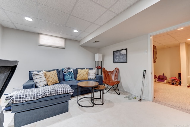 carpeted living room featuring a drop ceiling