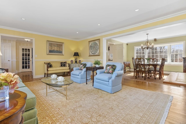 living area with a notable chandelier, crown molding, wood finished floors, and recessed lighting