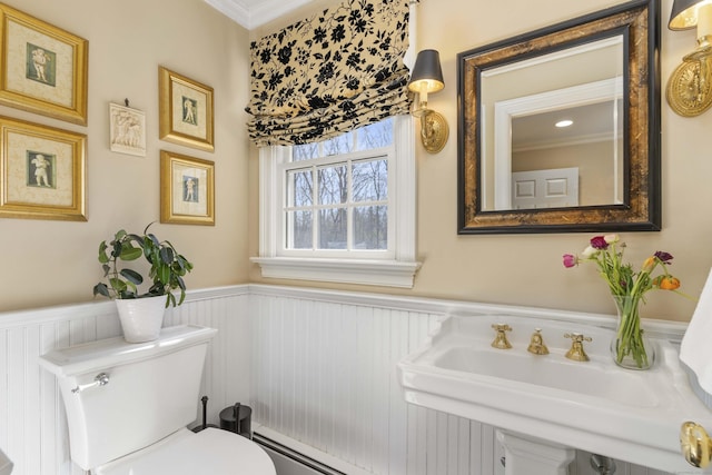 bathroom featuring a wainscoted wall, a sink, and toilet