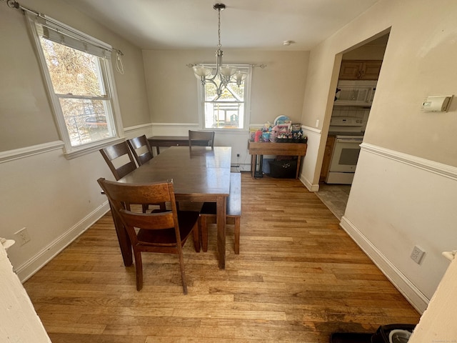 dining space with a chandelier and light wood-type flooring