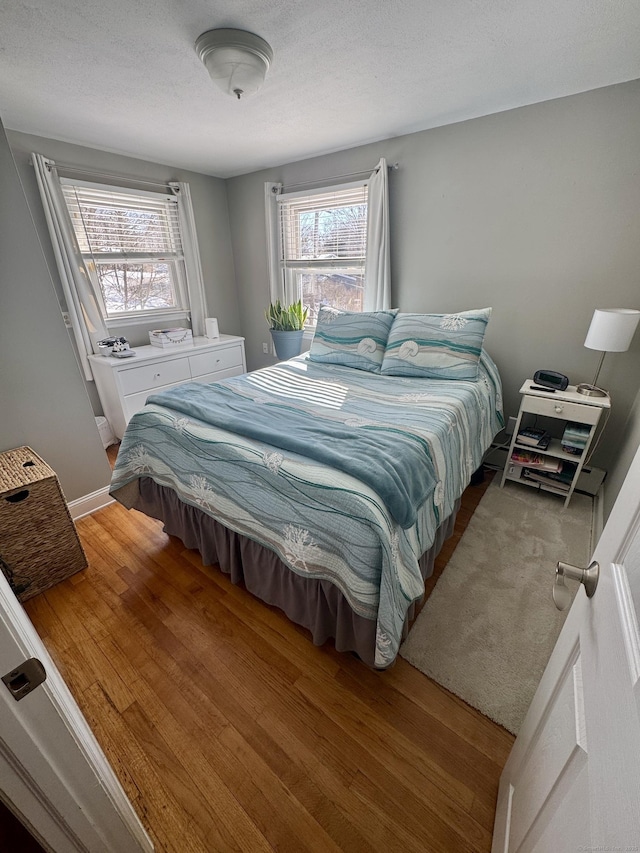 bedroom featuring wood-type flooring and a textured ceiling