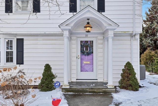 snow covered property entrance featuring cooling unit