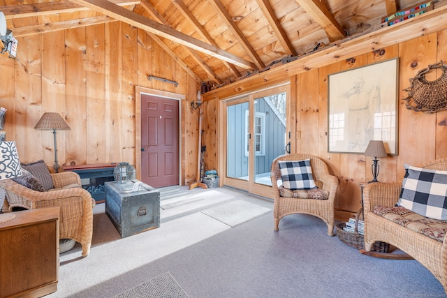 carpeted living room with wood ceiling, vaulted ceiling with beams, and wood walls