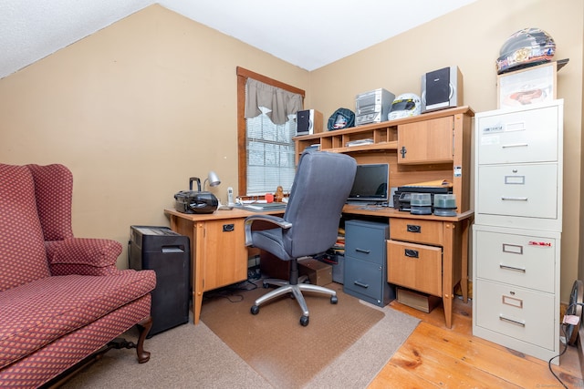 office space with vaulted ceiling and light wood finished floors