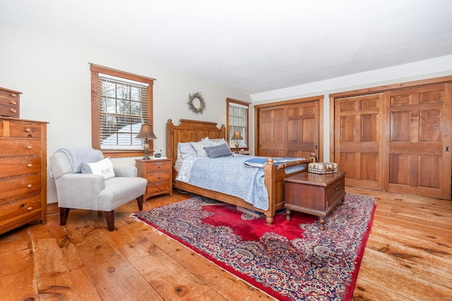 bedroom featuring light wood-type flooring and two closets