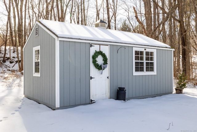 snow covered structure featuring an outbuilding