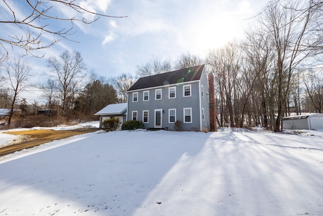 colonial home with a garage and a chimney