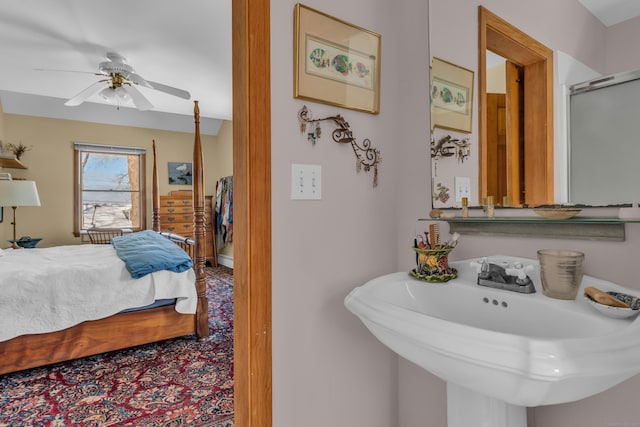 bathroom featuring ceiling fan, a shower with shower door, and sink