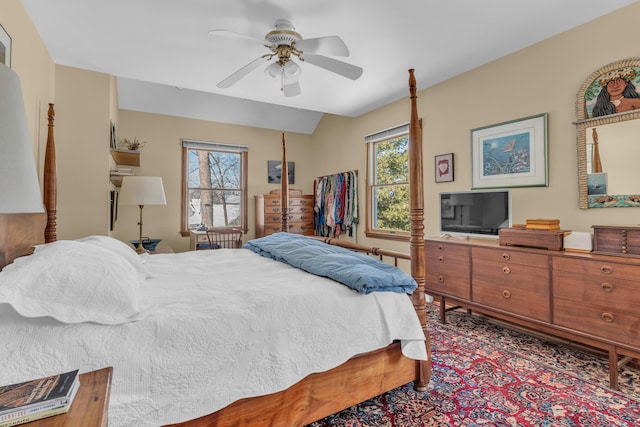 bedroom with ceiling fan, lofted ceiling, and multiple windows