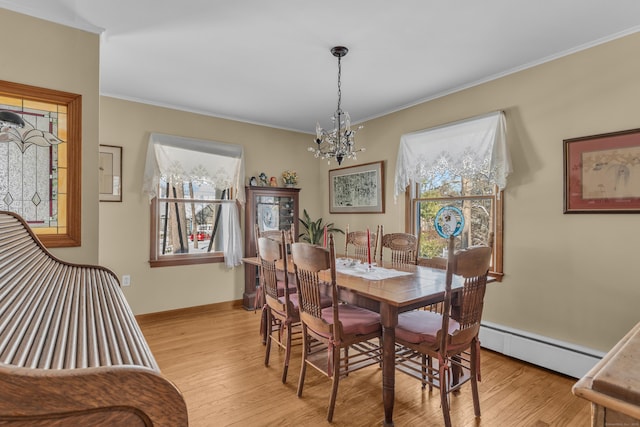 dining space with a baseboard radiator, crown molding, an inviting chandelier, and light wood-type flooring