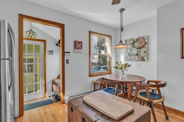 dining room with hardwood / wood-style flooring, lofted ceiling, and a baseboard heating unit