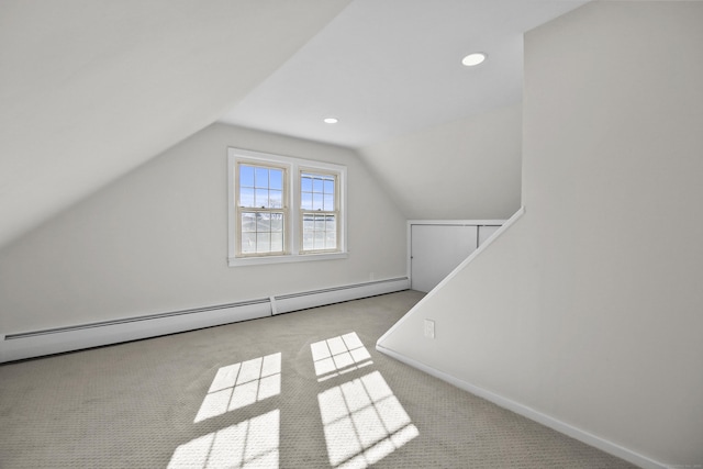 additional living space with lofted ceiling, light carpet, and baseboard heating