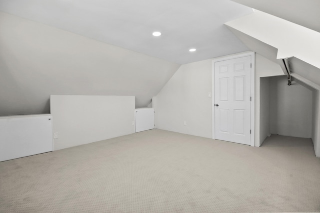 bonus room featuring light carpet and vaulted ceiling