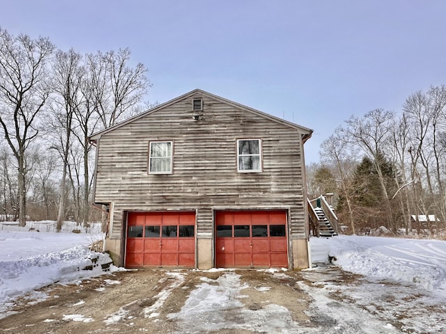 view of snowy exterior with a garage