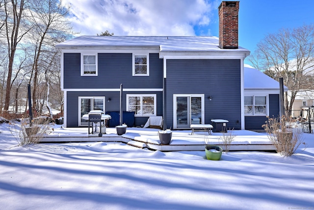 view of snow covered back of property