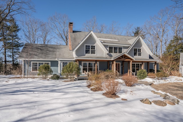 shingle-style home with a porch and a chimney