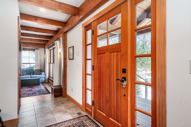 entrance foyer featuring beamed ceiling, baseboards, and visible vents