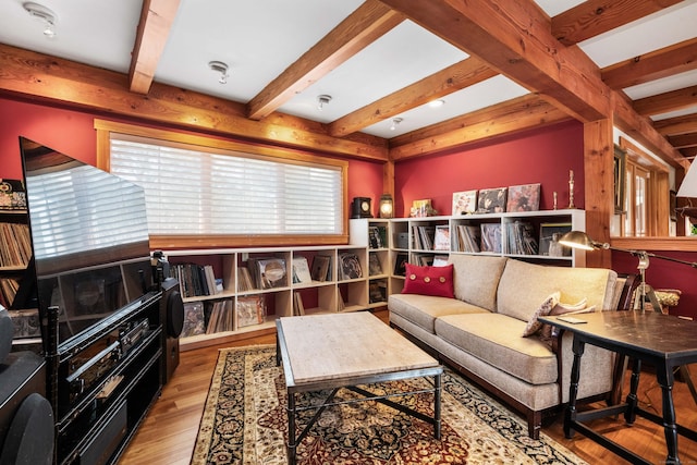 living area featuring beamed ceiling and wood finished floors