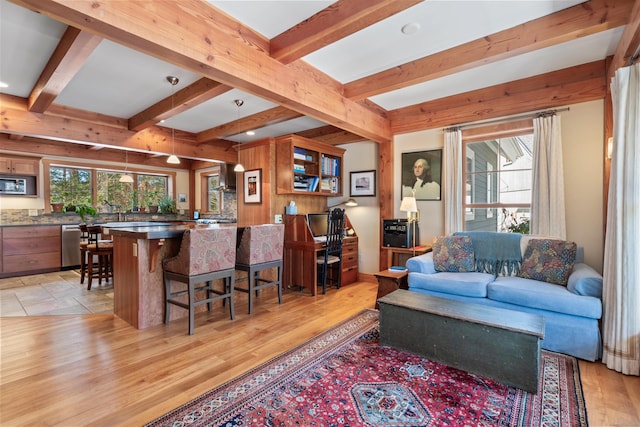 living area with light wood finished floors and beamed ceiling