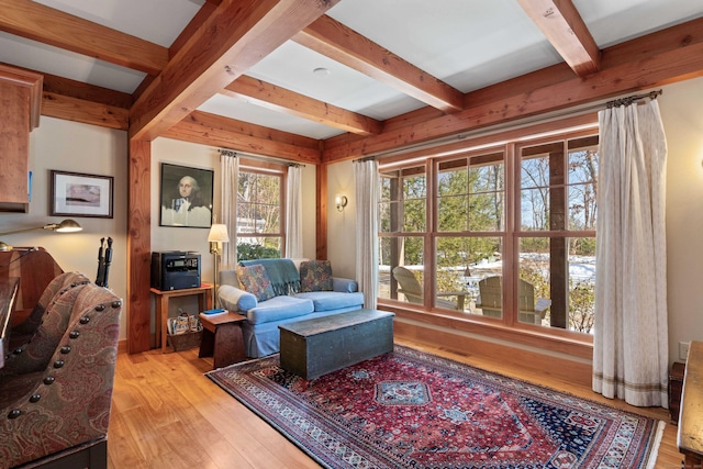 living room with beamed ceiling and light wood-style flooring