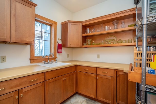 kitchen featuring a sink, open shelves, and brown cabinetry