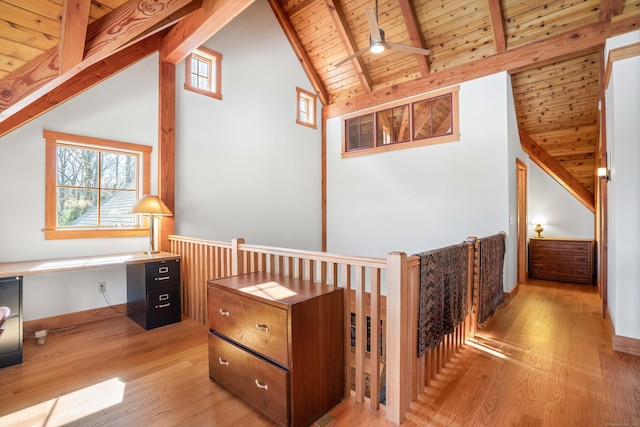 hallway featuring beam ceiling, a healthy amount of sunlight, wooden ceiling, and light wood finished floors