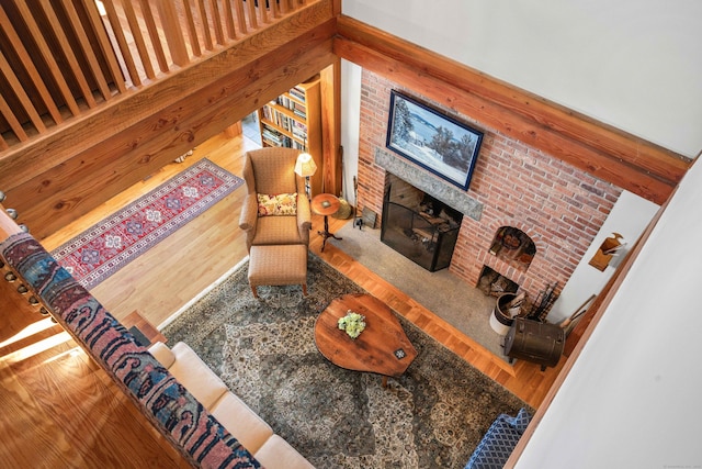 living area with a brick fireplace and wood finished floors