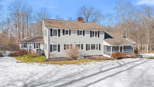 view of front facade featuring a chimney and a sunroom