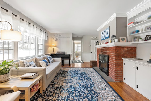 living room featuring ornamental molding, a fireplace, and wood finished floors