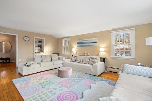 living area featuring a baseboard radiator, wood-type flooring, and vaulted ceiling