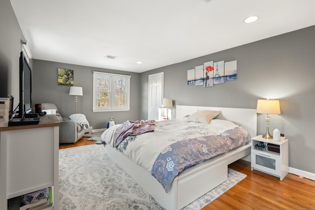 bedroom featuring baseboards, visible vents, wood finished floors, and recessed lighting