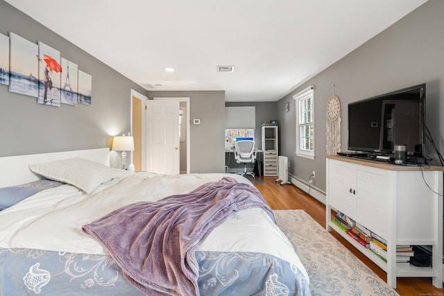 bedroom featuring visible vents and wood finished floors