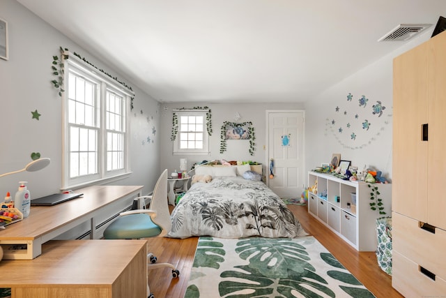 bedroom featuring wood finished floors and visible vents