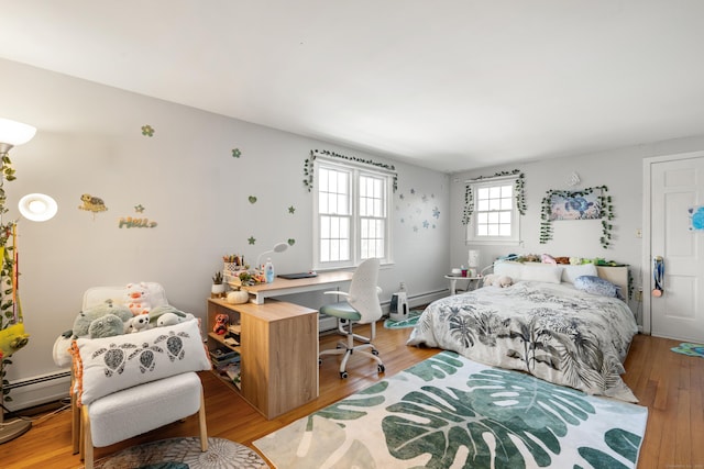 bedroom featuring baseboard heating and wood finished floors