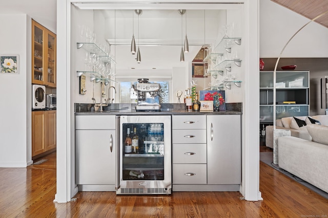 bar featuring sink, beverage cooler, and hardwood / wood-style floors