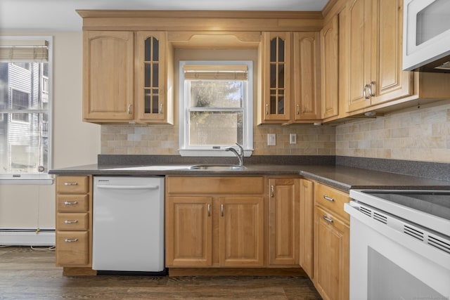 kitchen featuring dark countertops, glass insert cabinets, dark wood-type flooring, a sink, and white appliances