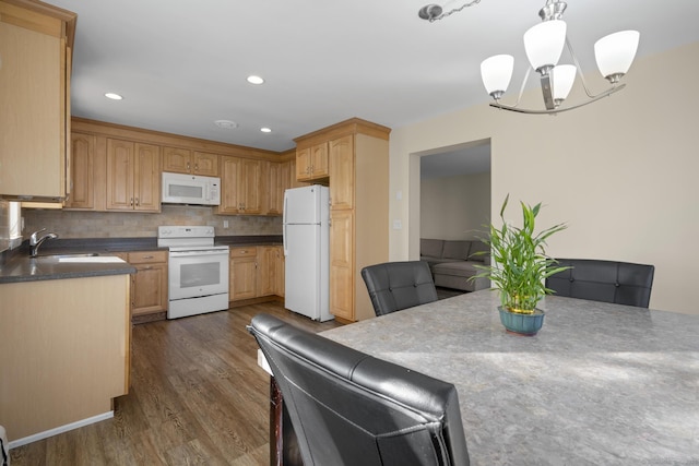 kitchen featuring dark wood-style floors, tasteful backsplash, an inviting chandelier, a sink, and white appliances