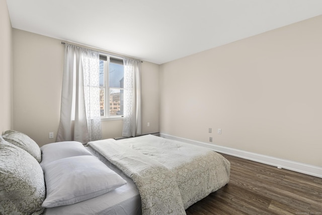 bedroom featuring baseboards and dark wood-type flooring