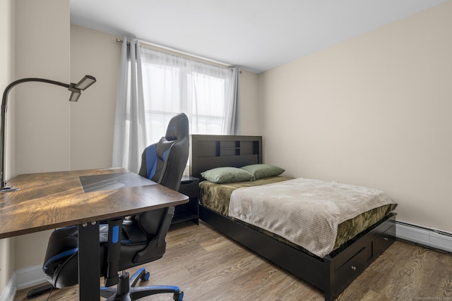 bedroom featuring a baseboard radiator and wood finished floors