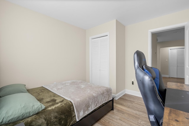 bedroom featuring a closet, wood finished floors, and baseboards