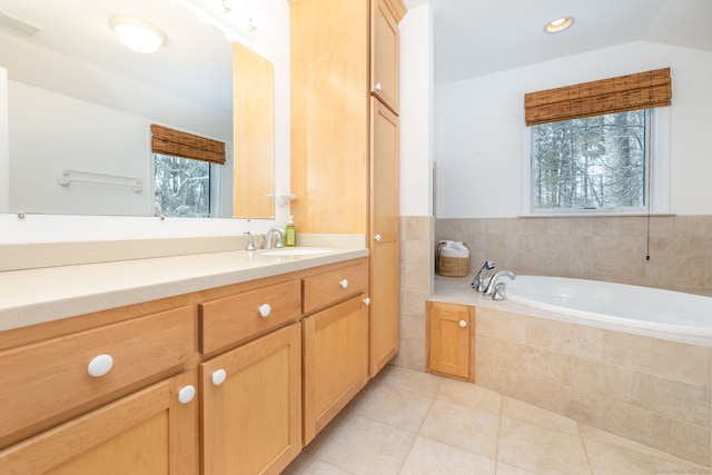 bathroom featuring a garden tub, visible vents, vaulted ceiling, vanity, and tile patterned flooring