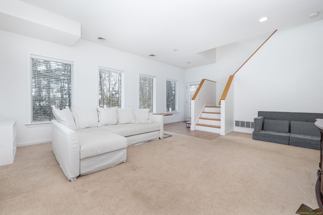 living room with recessed lighting, light carpet, visible vents, baseboards, and stairway