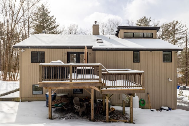 snow covered rear of property featuring a wooden deck