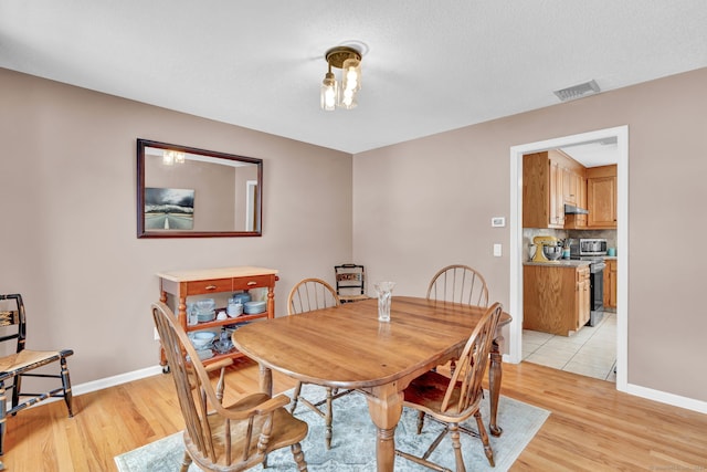 dining area featuring light hardwood / wood-style floors and a textured ceiling