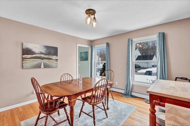 dining room featuring a textured ceiling and light wood-type flooring